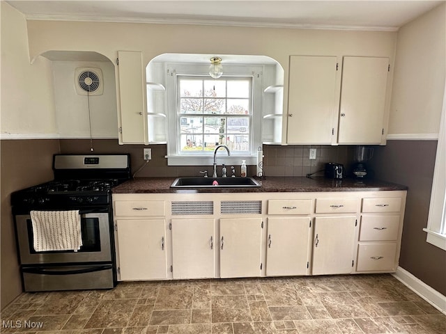 kitchen featuring white cabinets, backsplash, sink, and stainless steel range with gas stovetop