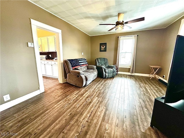 sitting room featuring ceiling fan, ornamental molding, and hardwood / wood-style flooring