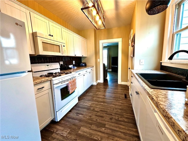 kitchen featuring sink, white cabinets, dark wood-type flooring, and white appliances