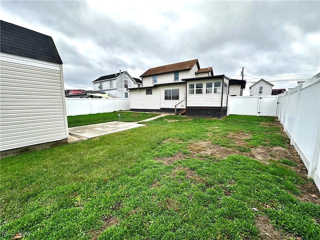 rear view of house with a lawn and a patio