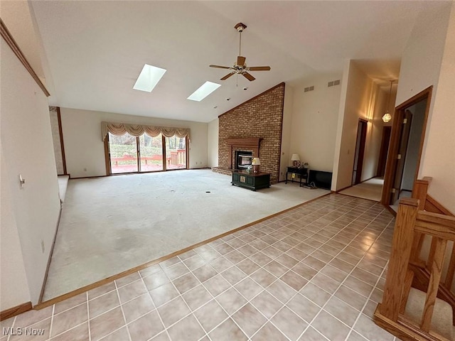 unfurnished living room featuring vaulted ceiling with skylight and ceiling fan