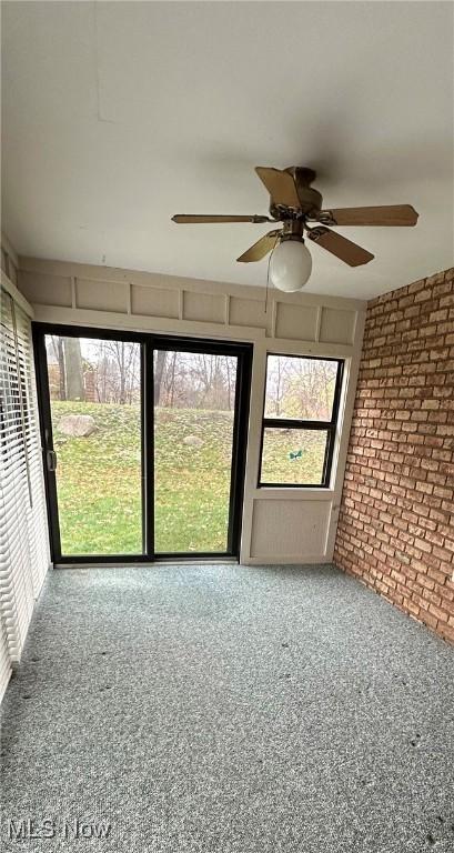 unfurnished sunroom with ceiling fan