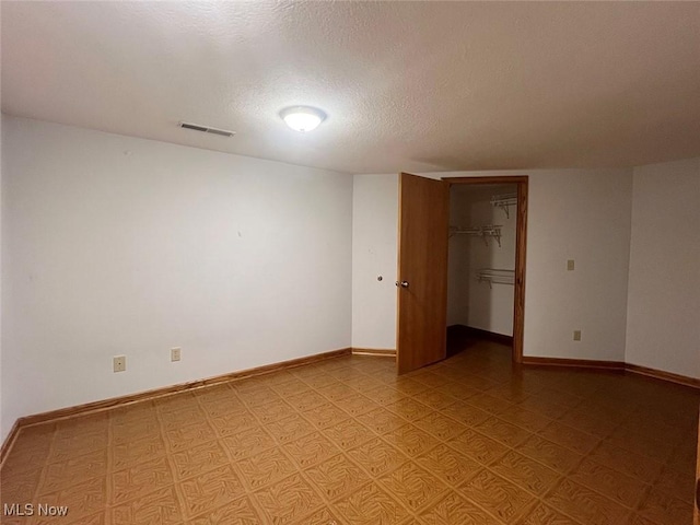 unfurnished room featuring a textured ceiling