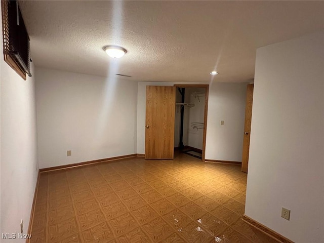 unfurnished room with a textured ceiling