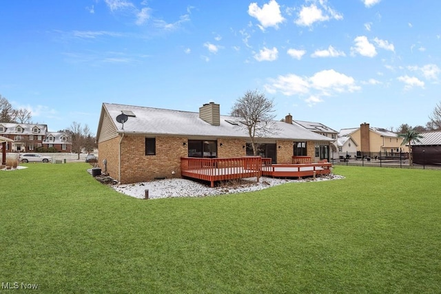 back of house featuring fence, a wooden deck, a yard, a chimney, and brick siding