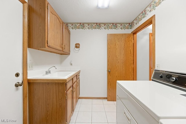 laundry room featuring washer / clothes dryer, light tile patterned flooring, cabinet space, a textured ceiling, and a sink