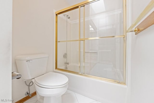 full bath with tile patterned floors, bath / shower combo with glass door, and toilet