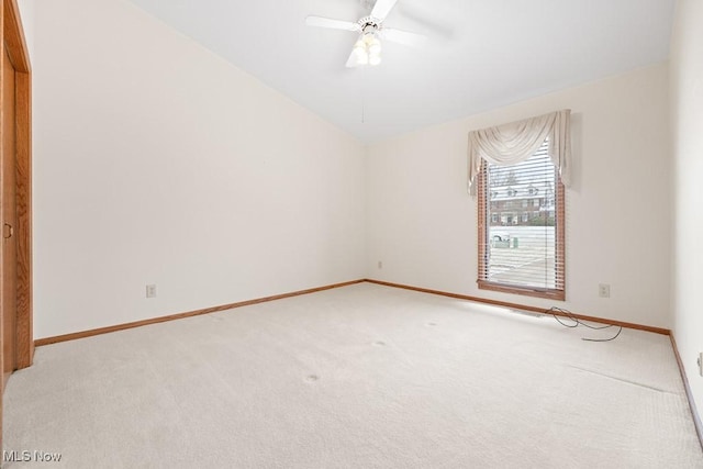 unfurnished room featuring light colored carpet, lofted ceiling, baseboards, and ceiling fan