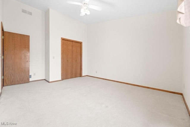 unfurnished bedroom featuring visible vents, ceiling fan, baseboards, light carpet, and a closet