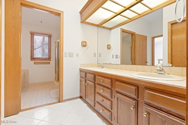 bathroom featuring double vanity, tile patterned floors, walk in shower, and a sink