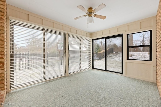 unfurnished sunroom with ceiling fan