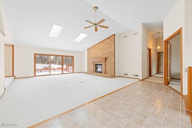 unfurnished living room with light tile patterned floors, visible vents, a skylight, light carpet, and a brick fireplace