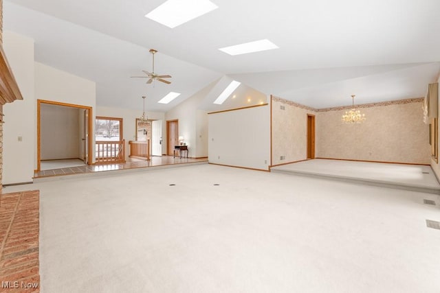 unfurnished living room with high vaulted ceiling, ceiling fan with notable chandelier, a skylight, baseboards, and light colored carpet