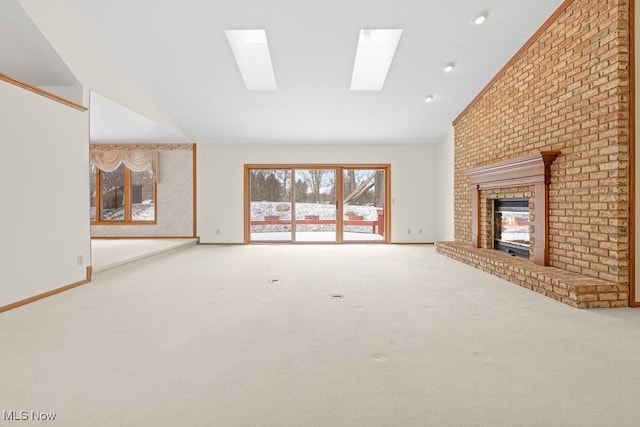 unfurnished living room featuring lofted ceiling, a brick fireplace, baseboards, and carpet floors