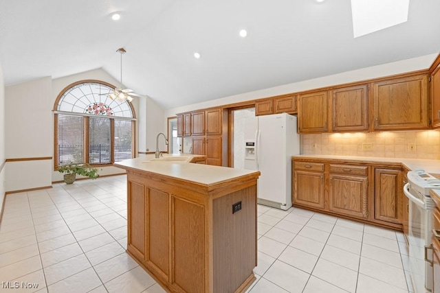 kitchen with tasteful backsplash, a center island with sink, light countertops, white appliances, and a sink