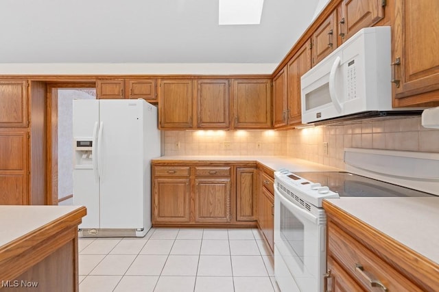 kitchen featuring backsplash, light countertops, light tile patterned floors, brown cabinets, and white appliances