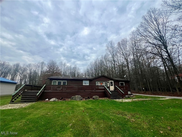 view of front of home featuring a wooden deck and a front yard