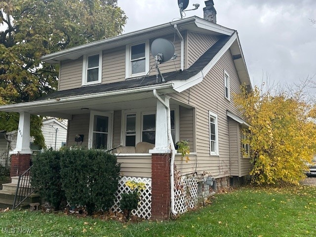 view of front of home with a porch and a front lawn