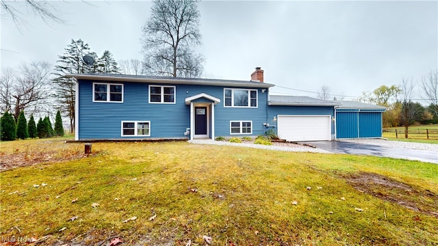 raised ranch featuring a front yard and a garage