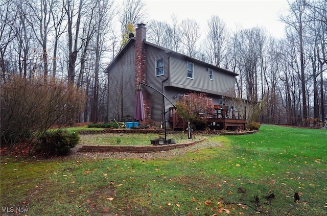 back of property featuring a wooden deck and a yard