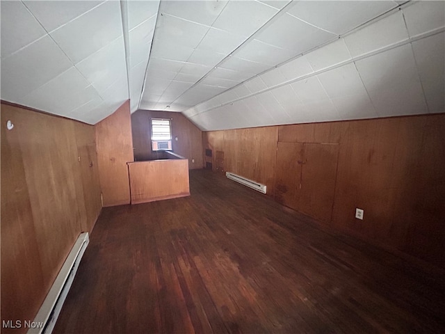 additional living space with dark hardwood / wood-style flooring, a baseboard radiator, vaulted ceiling, and wooden walls