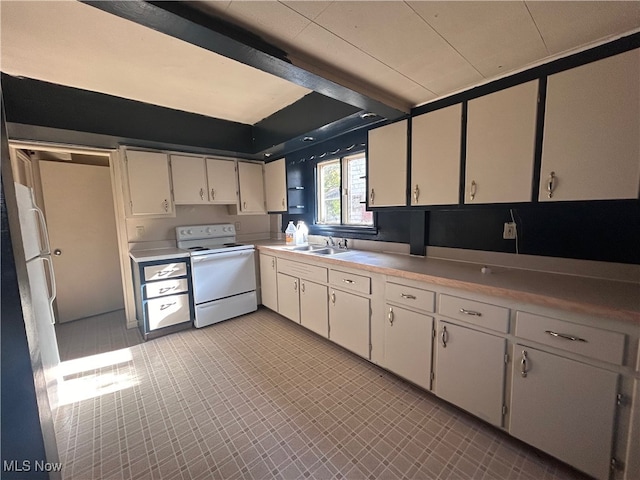 kitchen featuring sink, white cabinetry, and electric stove