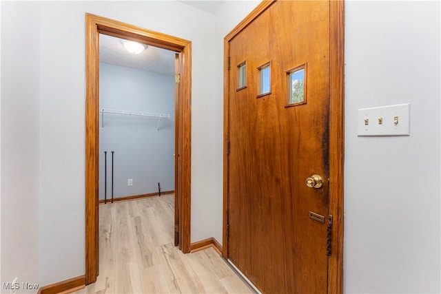 hallway featuring a textured ceiling and light hardwood / wood-style flooring