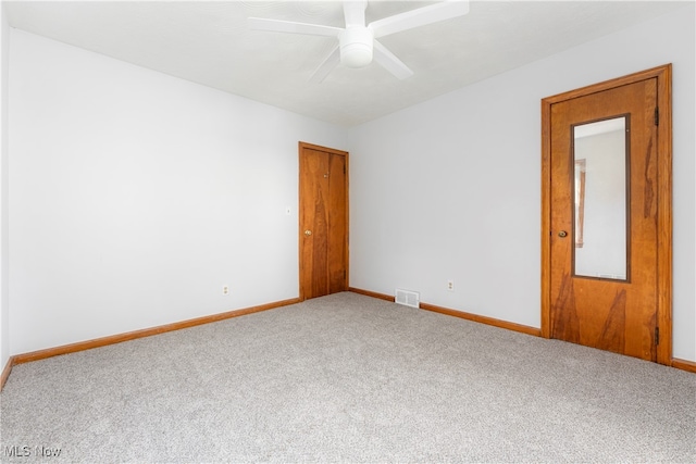 carpeted spare room with ceiling fan