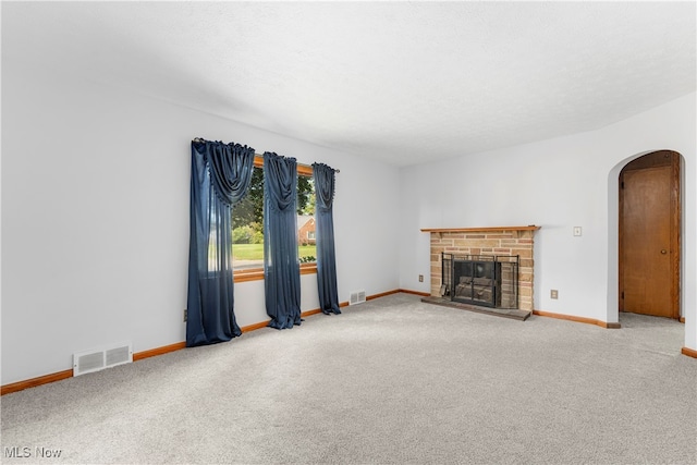 unfurnished living room featuring a fireplace, a textured ceiling, and carpet floors