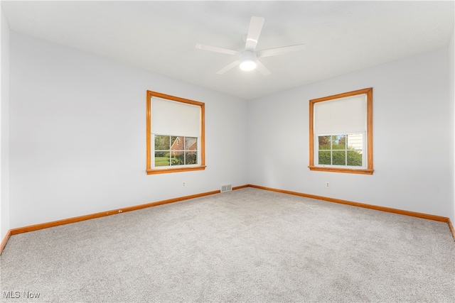 carpeted spare room featuring ceiling fan