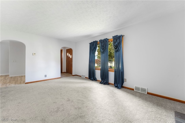 spare room featuring carpet and a textured ceiling