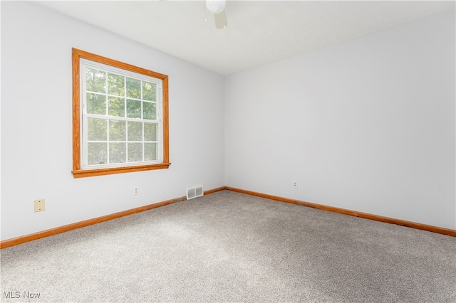 carpeted spare room with ceiling fan