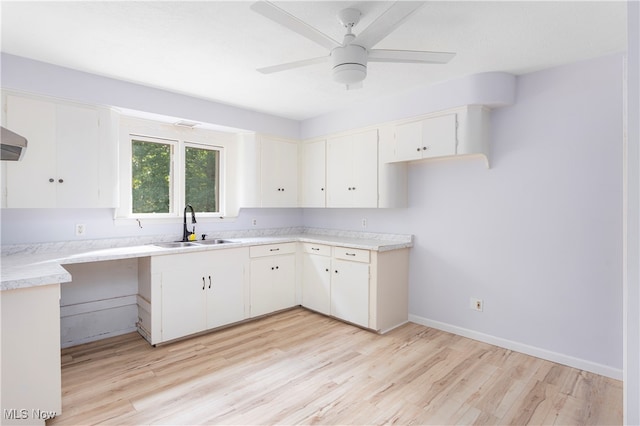 kitchen with ceiling fan, sink, white cabinets, and light hardwood / wood-style flooring