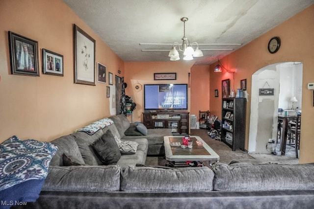 carpeted living room with a textured ceiling and a notable chandelier