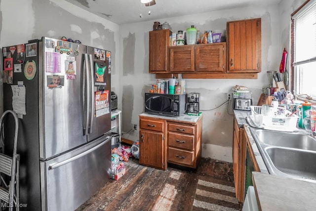 kitchen featuring dark hardwood / wood-style flooring, sink, and stainless steel refrigerator