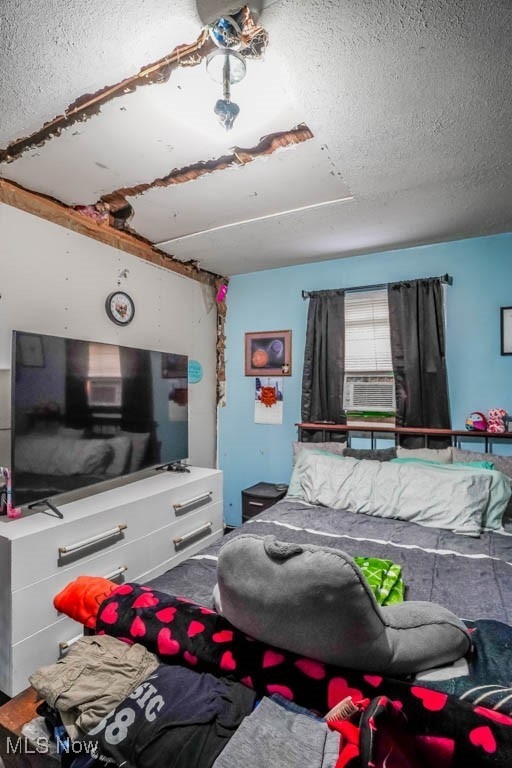 bedroom featuring cooling unit and a textured ceiling