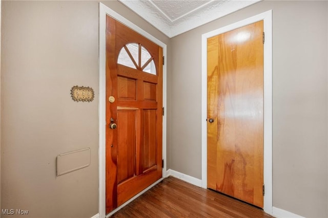 entryway featuring a textured ceiling, baseboards, and wood finished floors