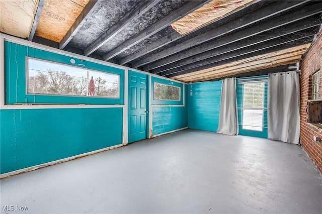 miscellaneous room with brick wall and concrete floors