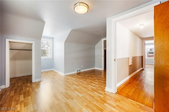 bonus room featuring visible vents, vaulted ceiling, baseboards, and wood finished floors