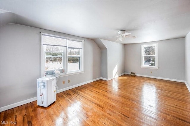 bonus room with light wood-style floors, lofted ceiling, visible vents, and baseboards