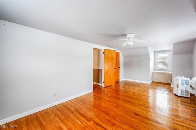 unfurnished room featuring ceiling fan, baseboards, and wood finished floors