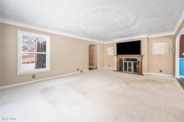 unfurnished living room with arched walkways, carpet floors, and a textured ceiling