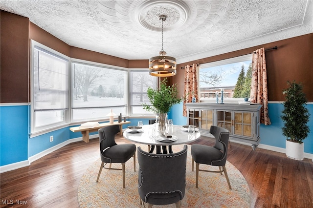 dining room with a textured ceiling, dark wood-style flooring, and baseboards