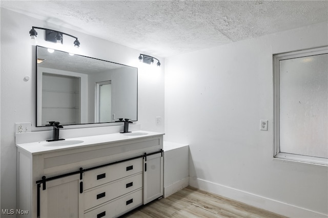 bathroom with vanity, a textured ceiling, and hardwood / wood-style flooring