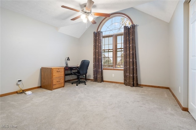 carpeted home office with a textured ceiling, vaulted ceiling, and ceiling fan