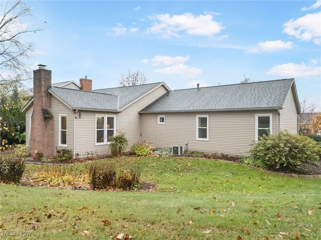 back of house featuring central AC and a lawn