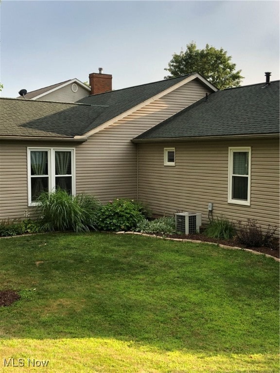 view of home's exterior featuring central AC unit and a yard