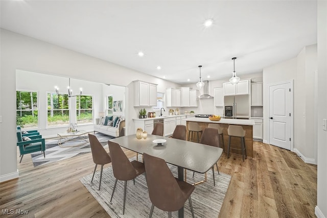 dining room featuring light hardwood / wood-style floors, an inviting chandelier, and sink
