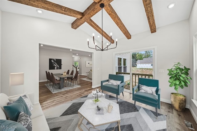 living room featuring a chandelier, lofted ceiling with beams, and hardwood / wood-style flooring