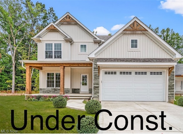 craftsman house featuring a front yard, a garage, and covered porch